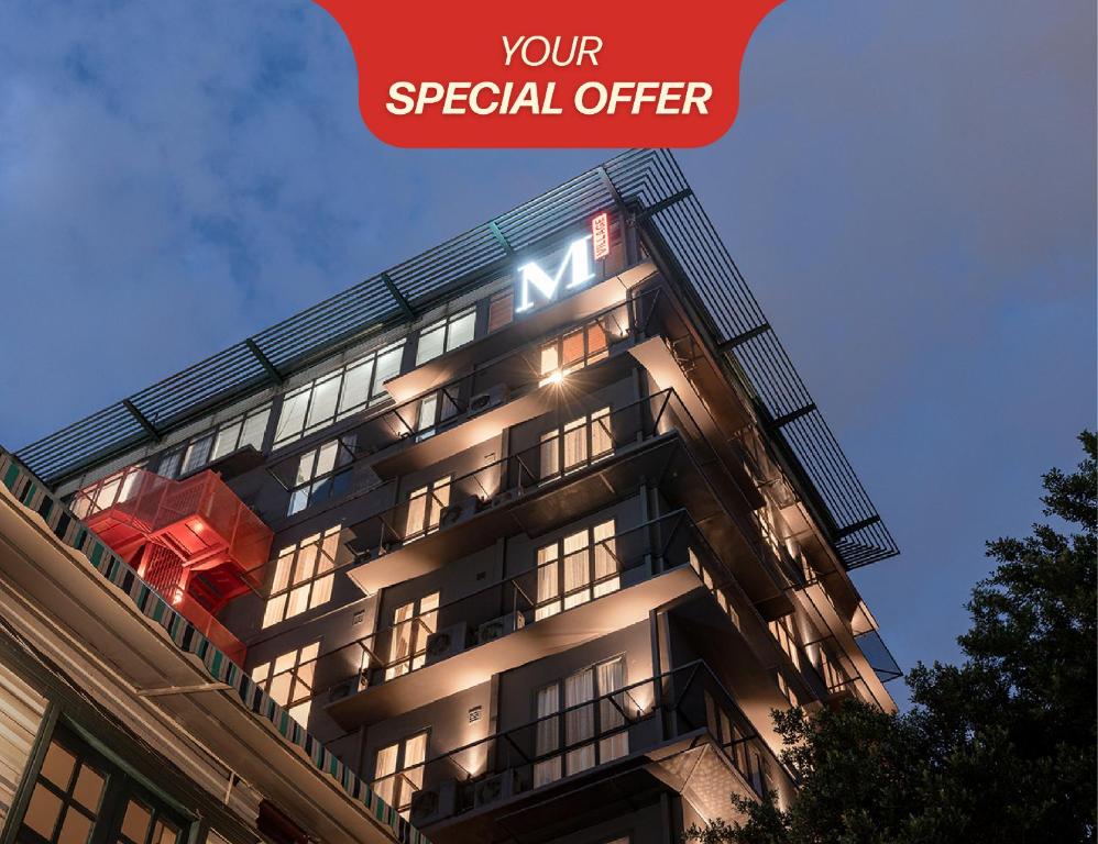 Un edificio con un cartel al costado. en M Village Hotel Hai Bà Trưng, en Ho Chi Minh