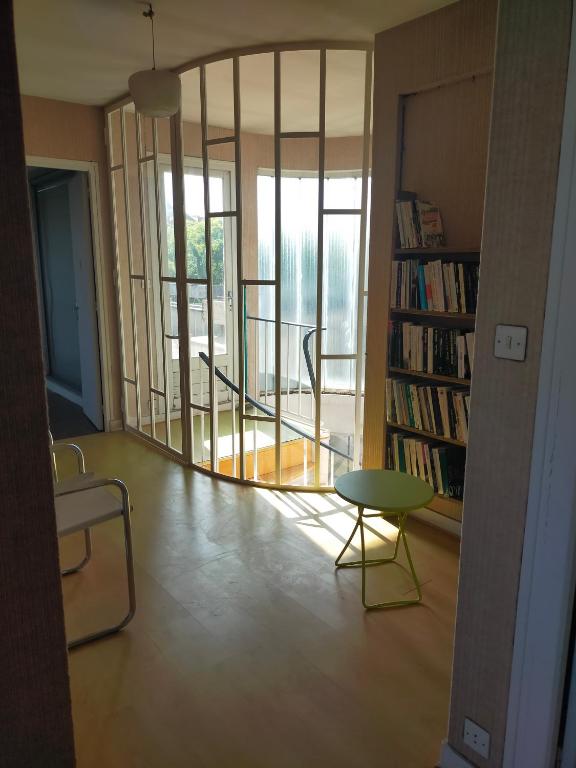 a living room with a table and a book shelf at les terrasses du Thouet in Parthenay