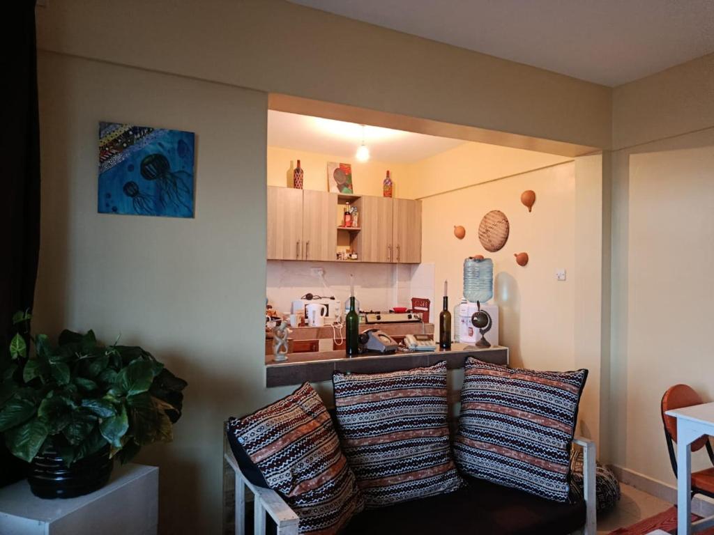 Una sala de estar con un sofá y una cocina. en Enkan Naserian, en Kilifi