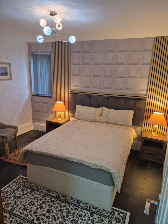 a bedroom with a large bed and two lamps at Ulverston Town Centre Ground Floor Apartment in Ulverston