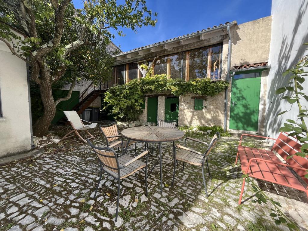 eine Terrasse mit Tisch und Stühlen vor einem Gebäude in der Unterkunft Maison de la Beureliere in Sainte-Marie-de-Ré