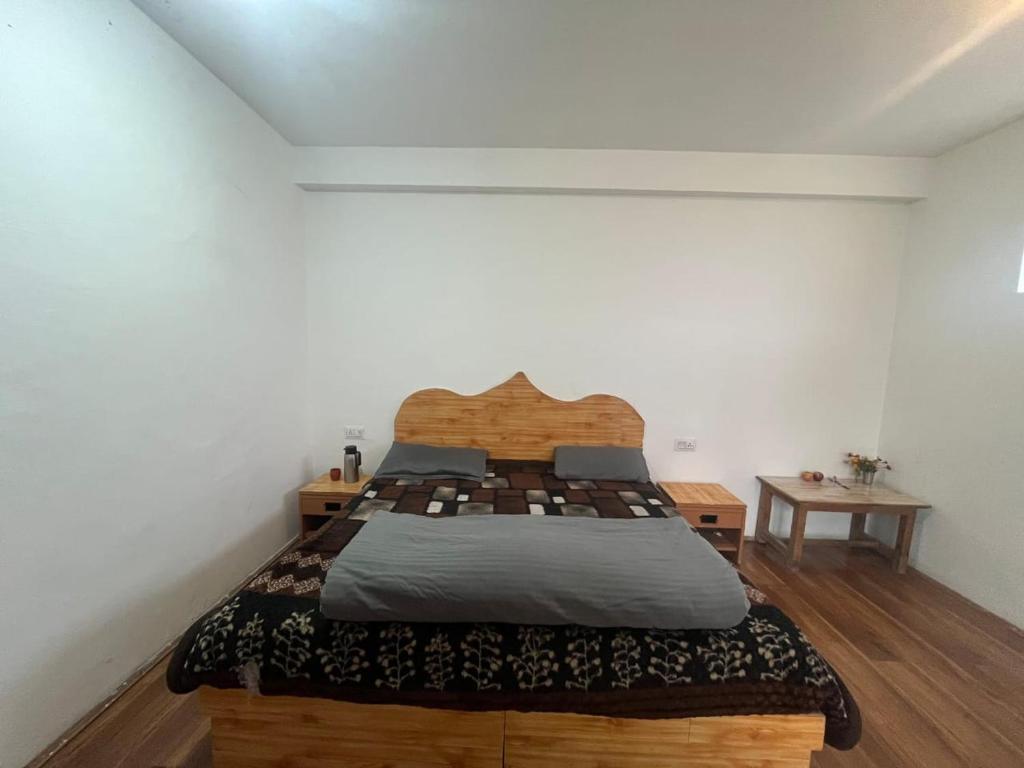 a bedroom with a large bed with a wooden headboard at Samora Retreats, Manali in Vashisht