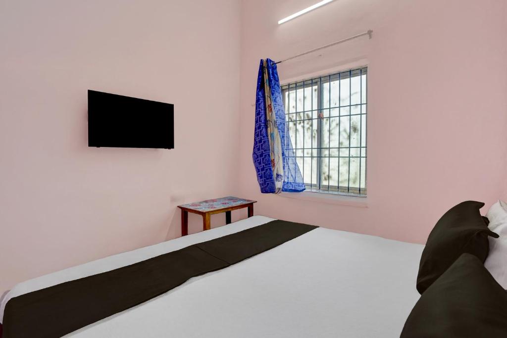 a white bedroom with a bed and a window at Hotel O Royal Stay in Bhilai