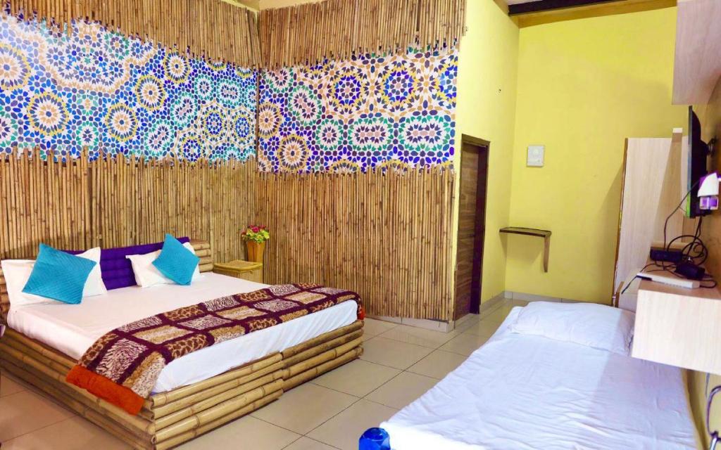 Mera Gaon Mera Desh Resort في سونيبات: غرفة نوم بسريرين في غرفة بجدار