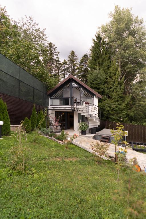 a small house in a yard with a garden at Cabana din padure in Agapia
