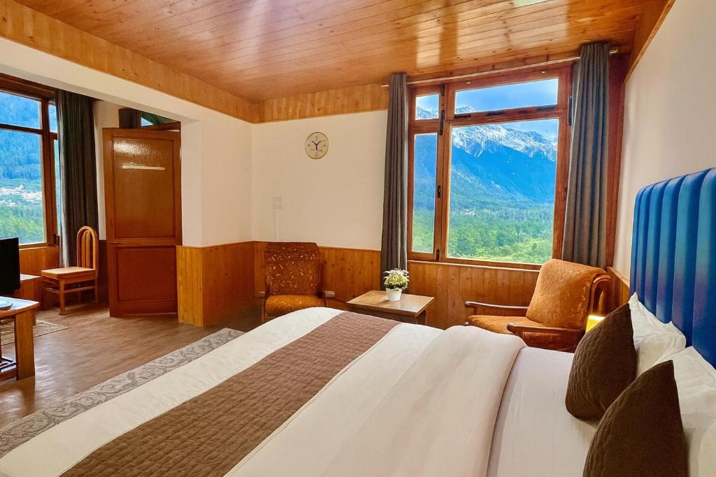a hotel room with a bed and a large window at Himalayan Crescent 2 Bedroom Luxury independent Villas Manali in Manāli