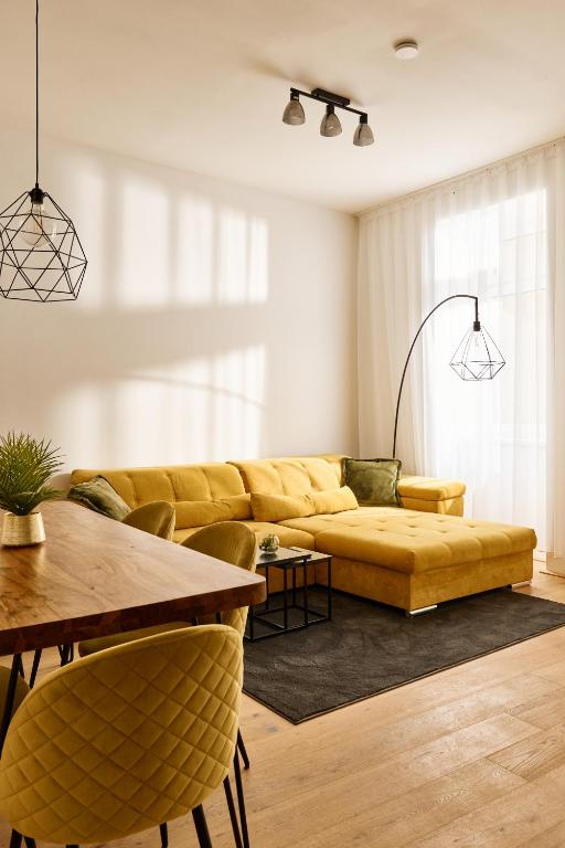 a living room with a yellow couch and a table at Melody Apartments Vienna - Modern & Spacious with Terrace in Vienna