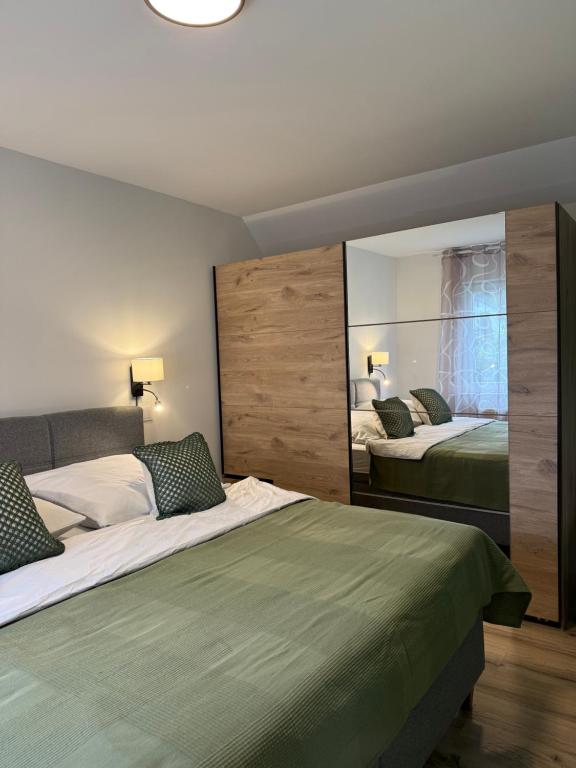 een slaapkamer met twee bedden en een grote spiegel bij Ferienwohnung in den Mühlgärten in Dahn