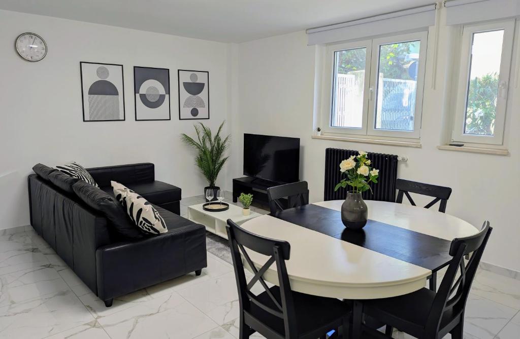 a living room with a table and a couch at Casa Rossini - Moderno appartamento a due passi dal mare in Pescara