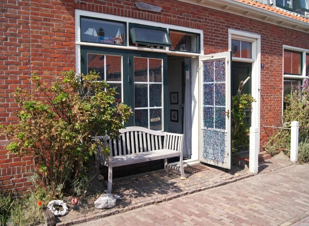 a bench in front of a building with a door at Studio 't Krekeltje in Westkapelle