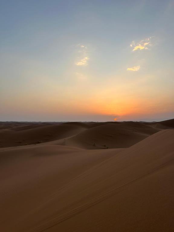 a sunset over the sand dunes in the desert at Desert tours&trips in Zagora