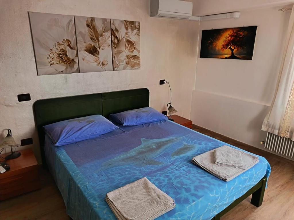 a bedroom with a blue bed with two towels on it at Il Casale del Miele in Fraforeano