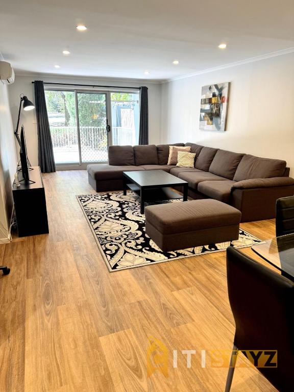 a living room with a couch and a table at Comfortable & Spacious -2bd 2bth - Braddon in Canberra