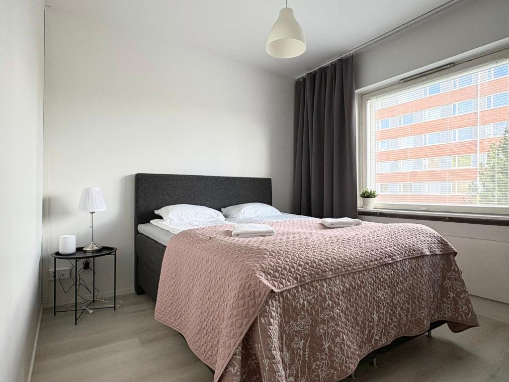 a bedroom with a bed with a pink blanket at Aava's apt. FREE Parking in Pori