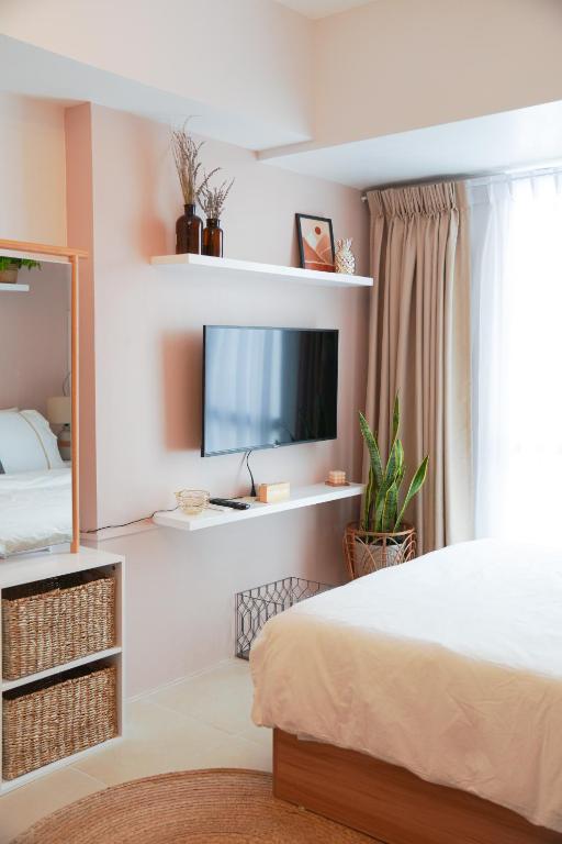a bedroom with a bed and a flat screen tv at Cozy Nest Tagaytay in Tagaytay