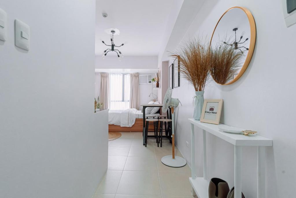 un couloir blanc avec un miroir et une chambre dans l'établissement Cozy Nest Tagaytay, à Tagaytay