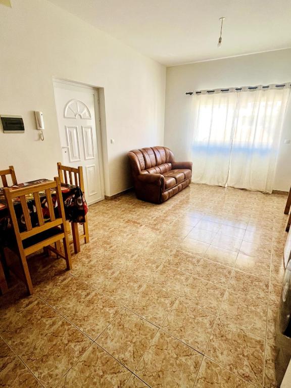 un soggiorno con un divano e un tavolo di GoBeyond - Serra T2 a Porto Novo