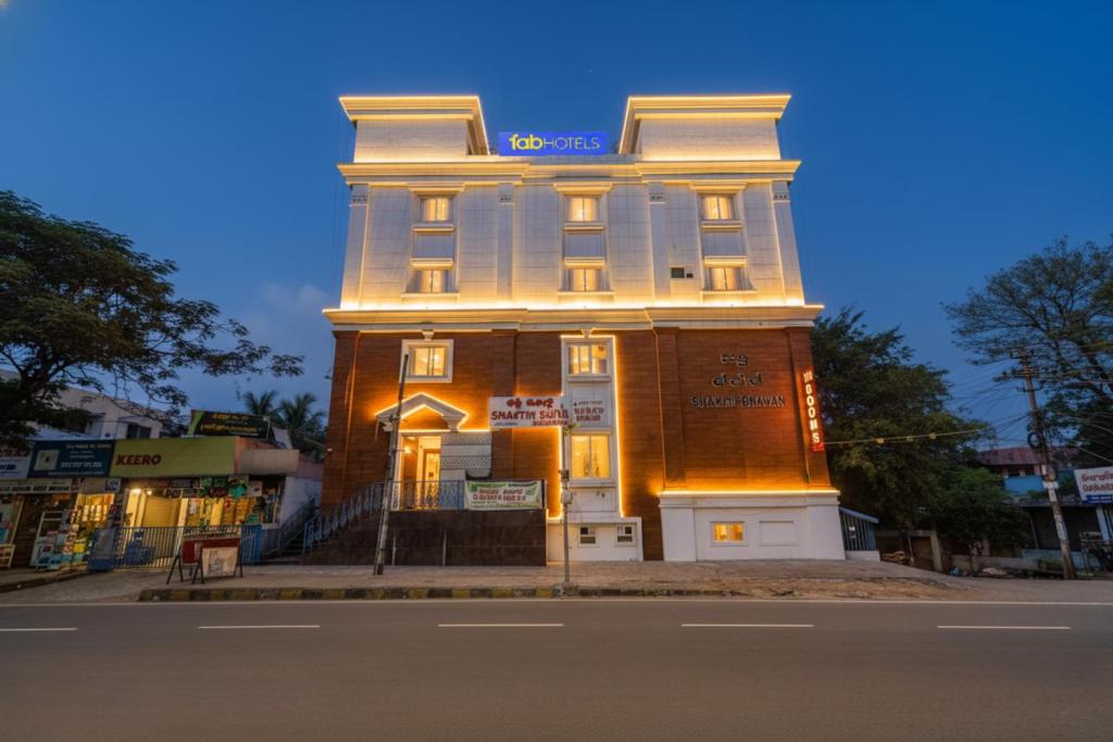 a building with a lit up facade on a street at FabHotel Shakthi Suites - Nr Jayadeva Hospital in Bengaluru