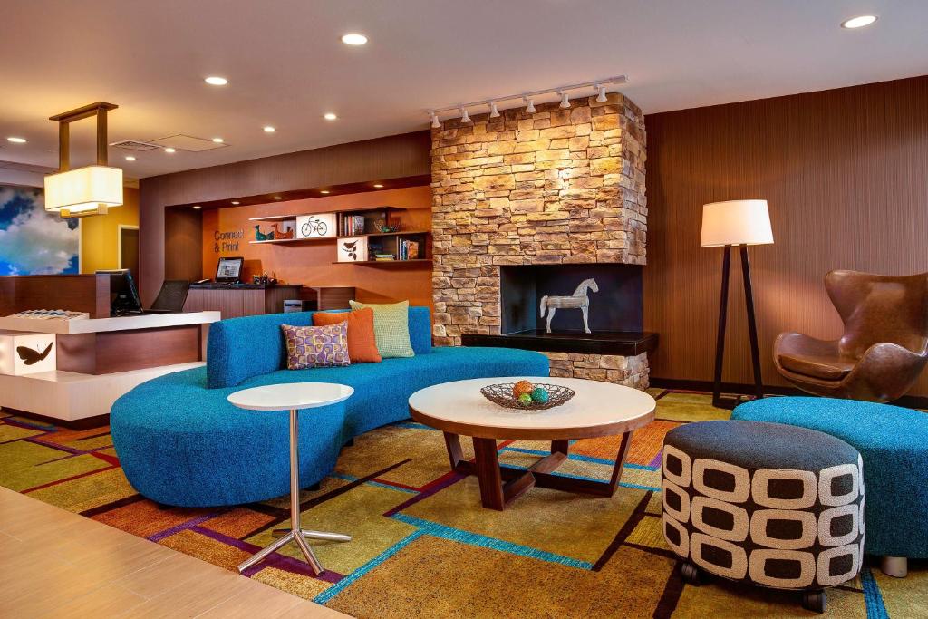 a living room with blue furniture and a fireplace at Fairfield Inn & Suites by Marriott Lincoln Southeast in Lincoln