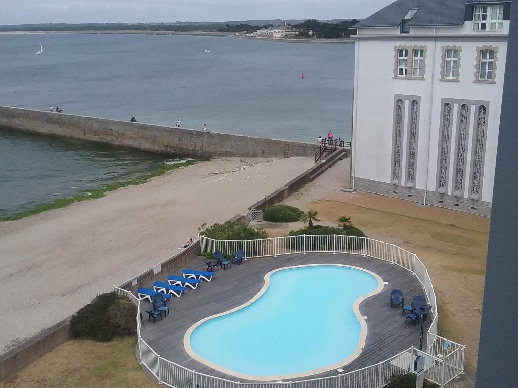 uma piscina ao lado de uma praia e um edifício em Le Croisic Face Mer em Le Croisic