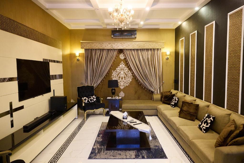 ein Wohnzimmer mit Sofa und Fernseher in der Unterkunft Sandhu farmhouse in Lahore