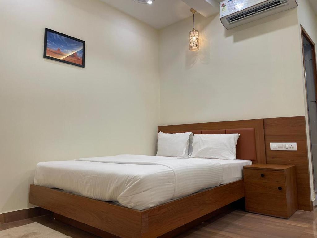 a bedroom with a bed and a air conditioner at The Marina Deluxe Kozhikode - Premium Spacious AC Rooms in Kozhikode