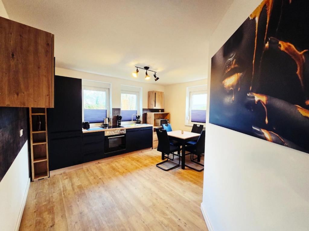 a kitchen with black cabinets and a table and chairs at Moritz Apartments - Am Rieseninger Berg 1 in Görmar