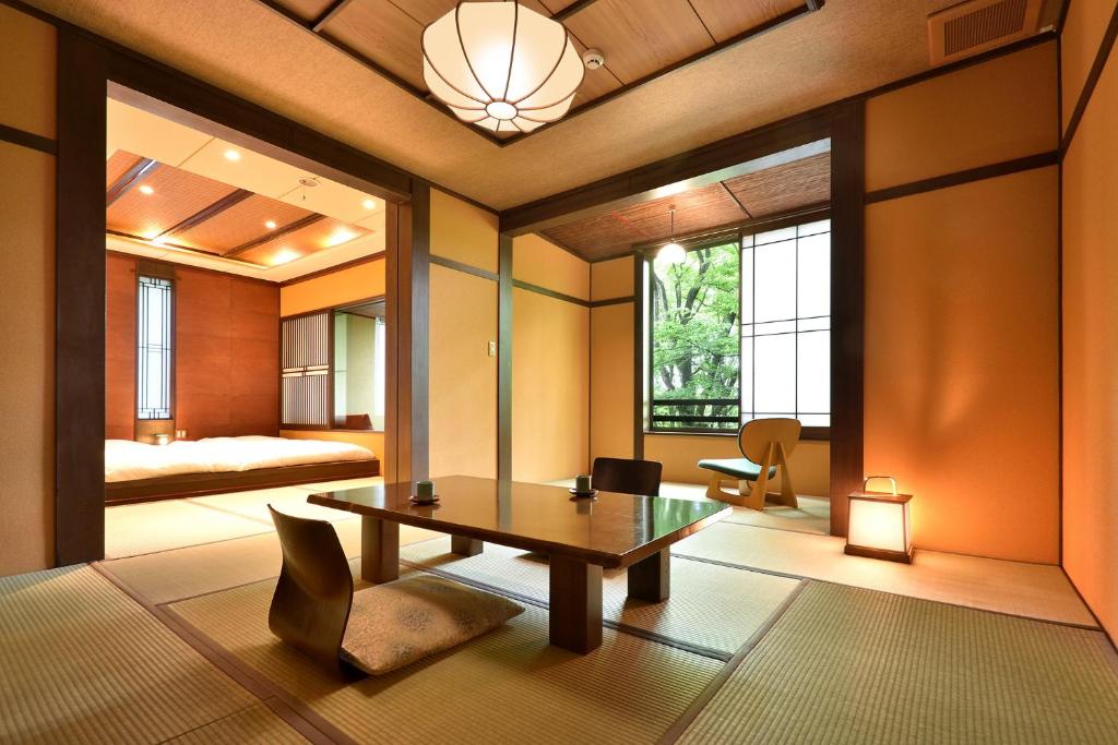 那須町にある那須高原の宿 山水閣のテーブルのある部屋とベッドのある寝室