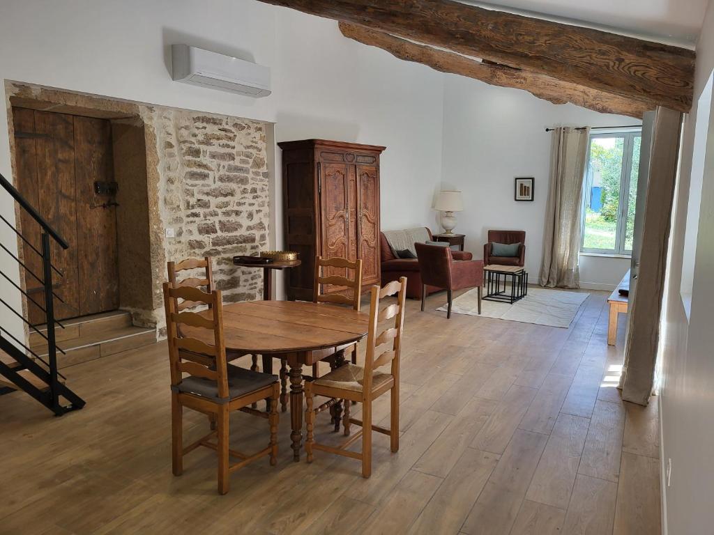 a living room with a wooden table and chairs at Gite l'olivier des maraichers in Albigny-sur-Saone