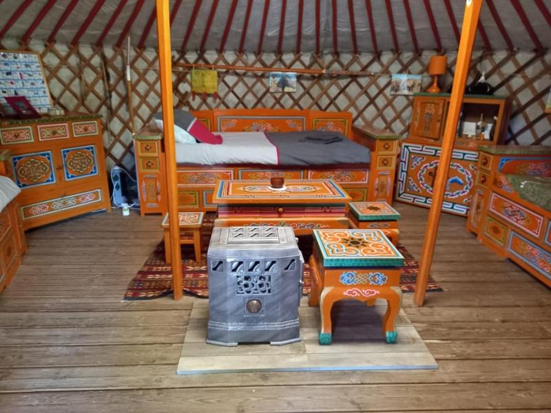 a room with two beds and a table in a yurt at yourte d'hotes in Mailley-et-Chazelot