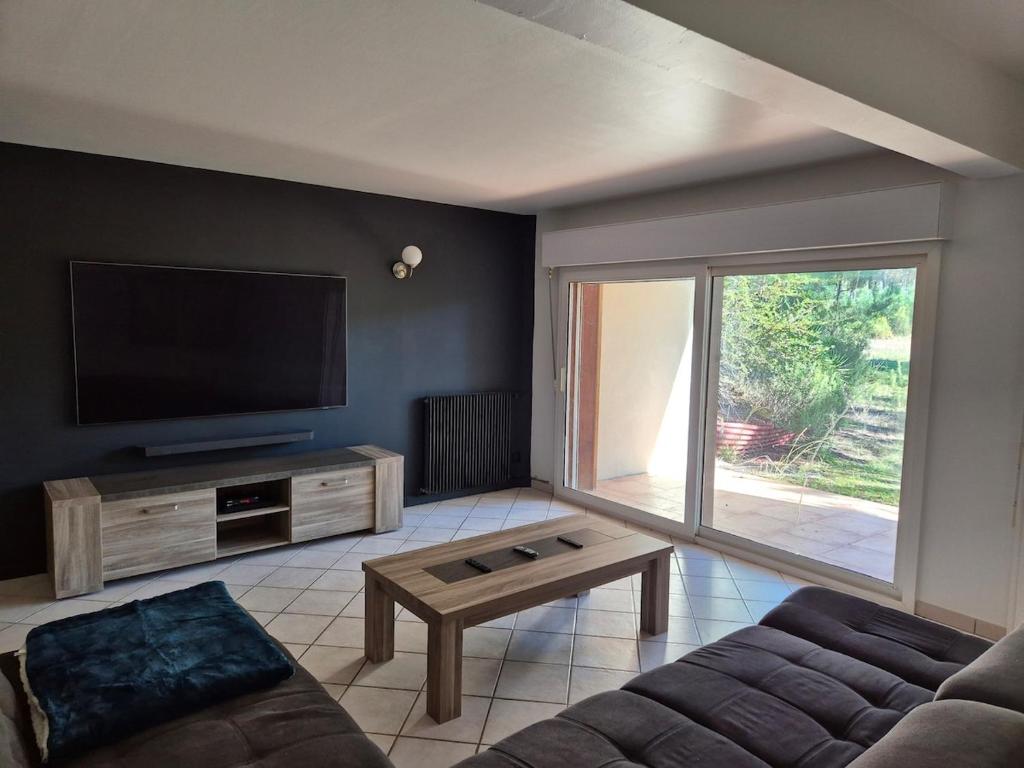 ein Wohnzimmer mit Couch und Flachbildfernseher in der Unterkunft Calme et paisible maison au milieu de la foret in Arx