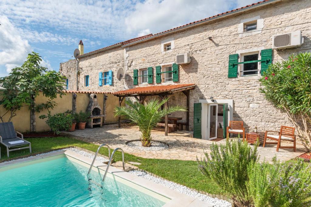 a house with a swimming pool in front of it at Casa Štifanići in Baderna