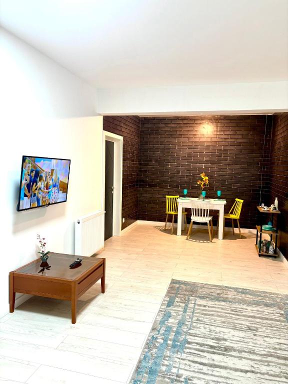 a living room with a table and yellow chairs at Residence 2 in Ploieşti