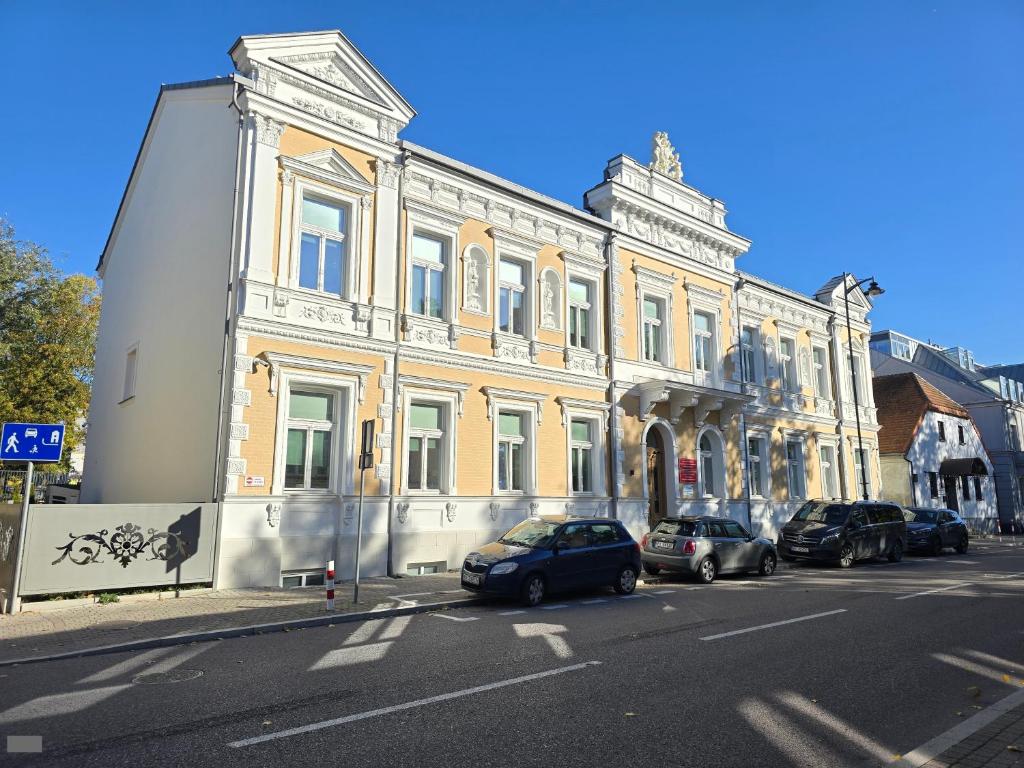 een gebouw waar auto's voor geparkeerd staan op straat bij Apartament Pałac Tryllingów in Białystok