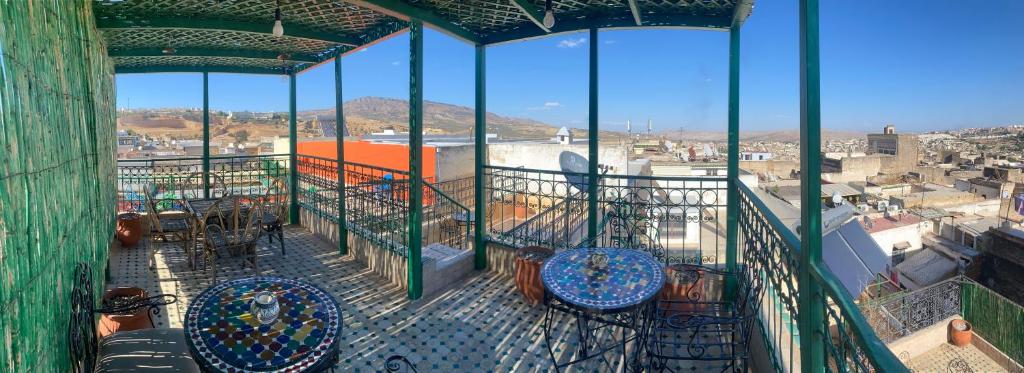 a balcony with chairs and a view of a city at RIAD LALJ Fes in Fès