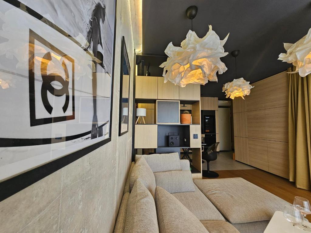 a living room with a couch and a chandelier at SUITE 74 apartment Šibenik Finnish sauna & underground garage parking in Šibenik