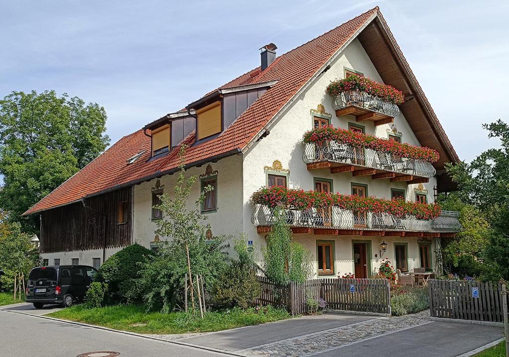 ムルナウ・アム・シュタッフェルゼーにあるSporerhofの花の咲くバルコニー付きの大きな家