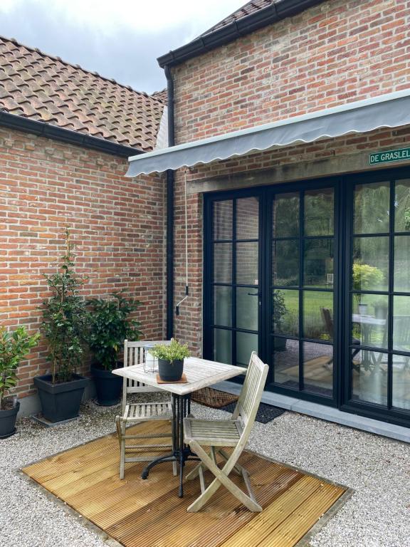 a patio with a table and chairs in front of a building at de graslelie in Schoten