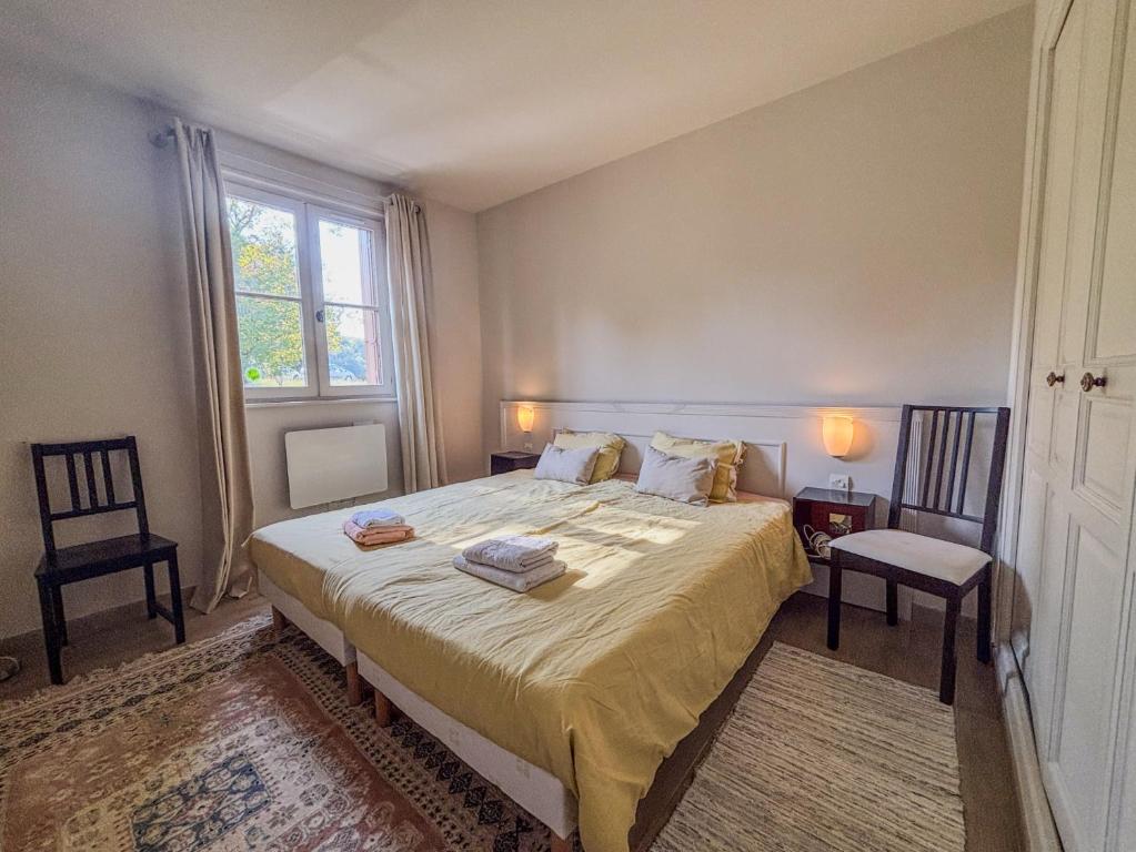 ベレームにあるJoli T3 au pied du Golf - The 19th Holeの大きなベッドと椅子2脚のある寝室