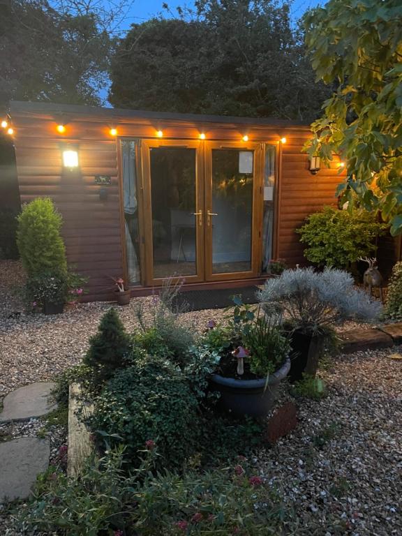 a small house with a bunch of plants in front of it at Deer Lodge in Thornton Curtis