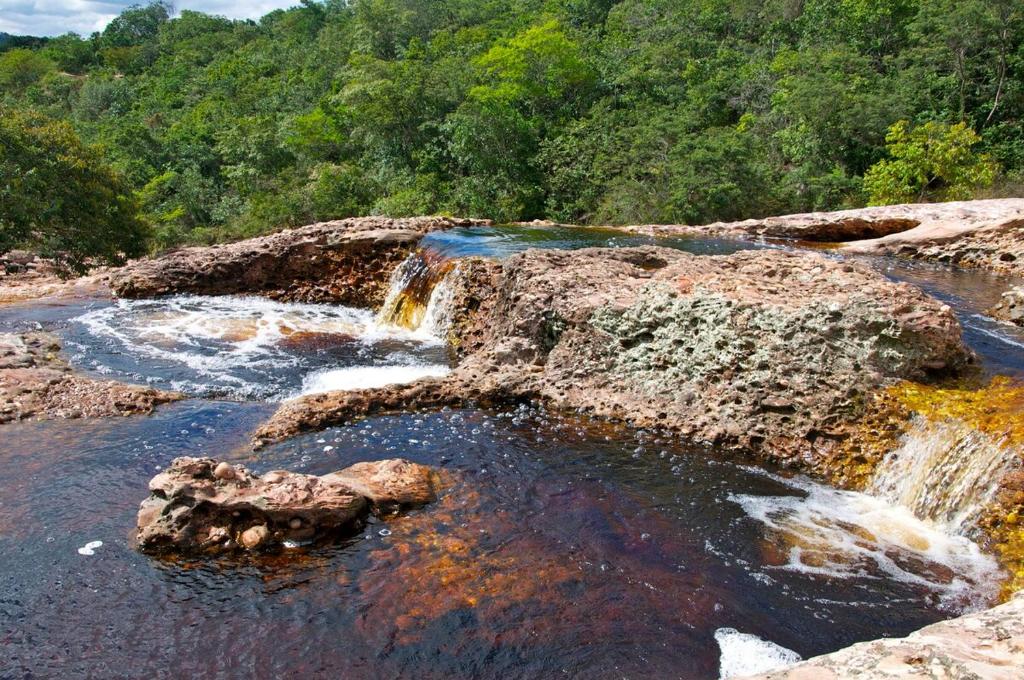 una cascada en un río con rocas y árboles en Casa LV, en Lençóis