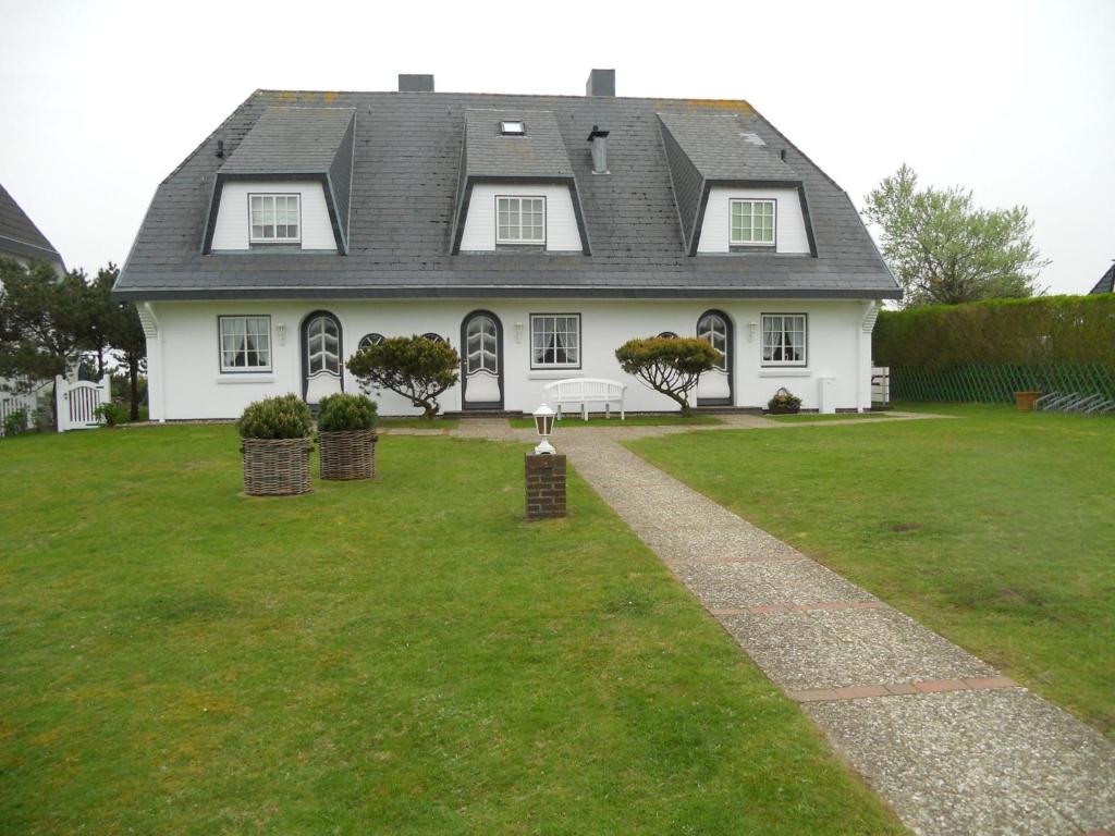 a large white house with a green yard at Ferienwohnung Sönshörn S8R In Munkmarsch in Munkmarsch