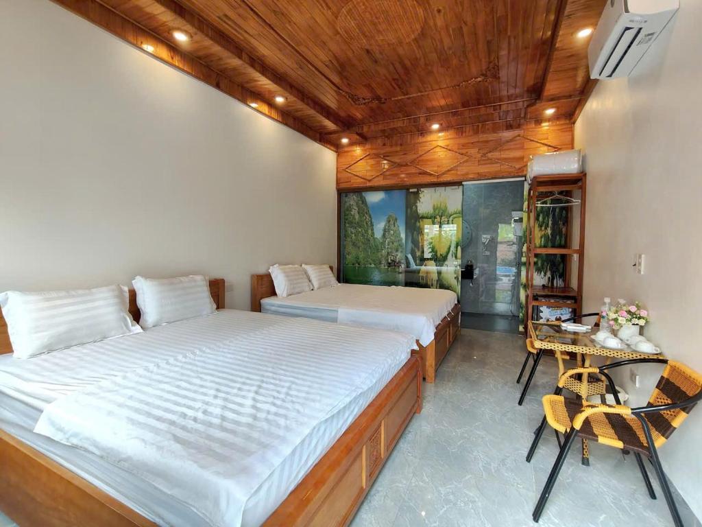 a bedroom with two beds and a table and chairs at Trang An Viet Anh Homestay in Nguyên Ngoại