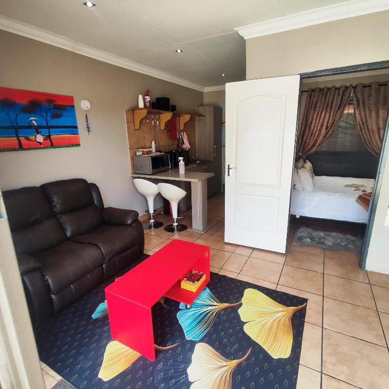 a living room with a couch and a table at Quiet Getaway in Bloemfontein