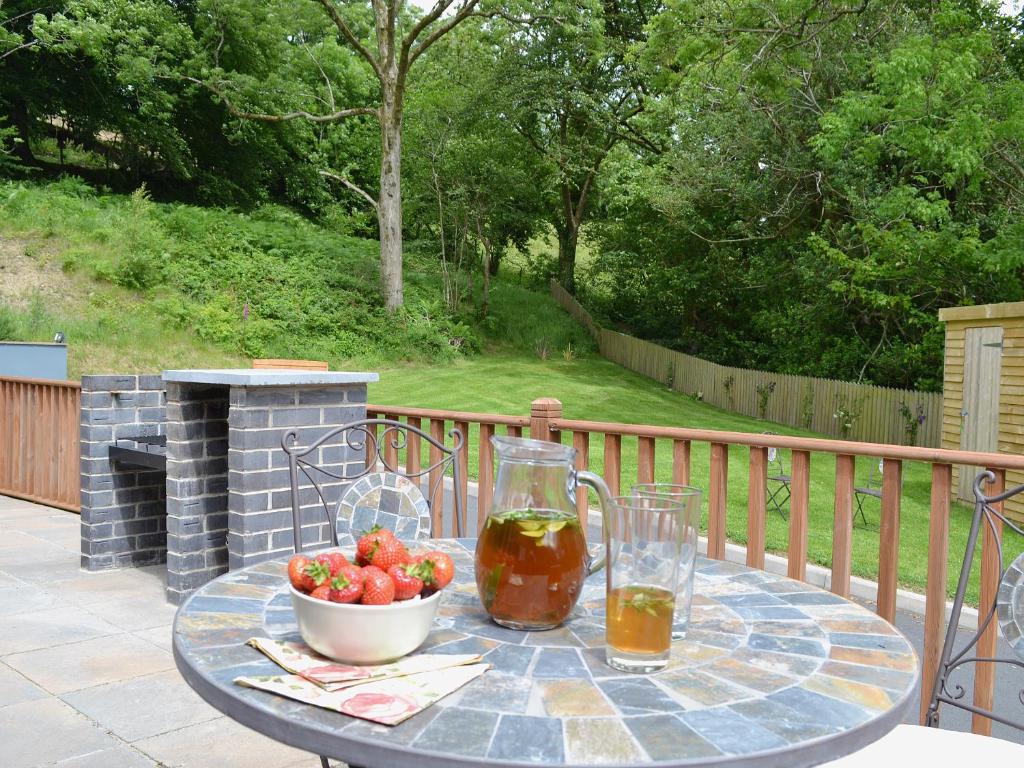 a table with a bowl of fruit on a patio at Beudy Bach-Oh5 in Dihewid