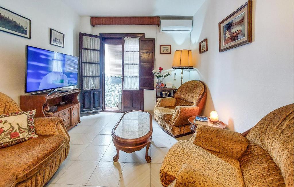 Una sala de estar con dos sofás y un televisor de pantalla plana. en Casa Del Arco, en Ronda