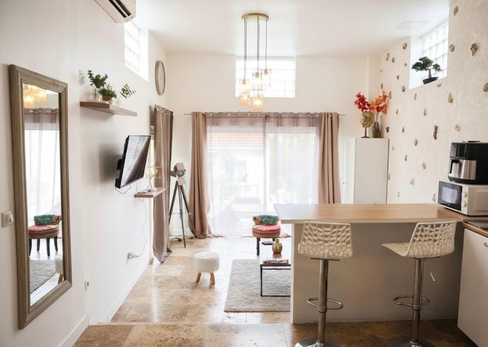 a kitchen with a table and chairs in a room at Maison 4 pers 10 min Disneyland Paris Terrasse Parking Gratuit in Chalifert