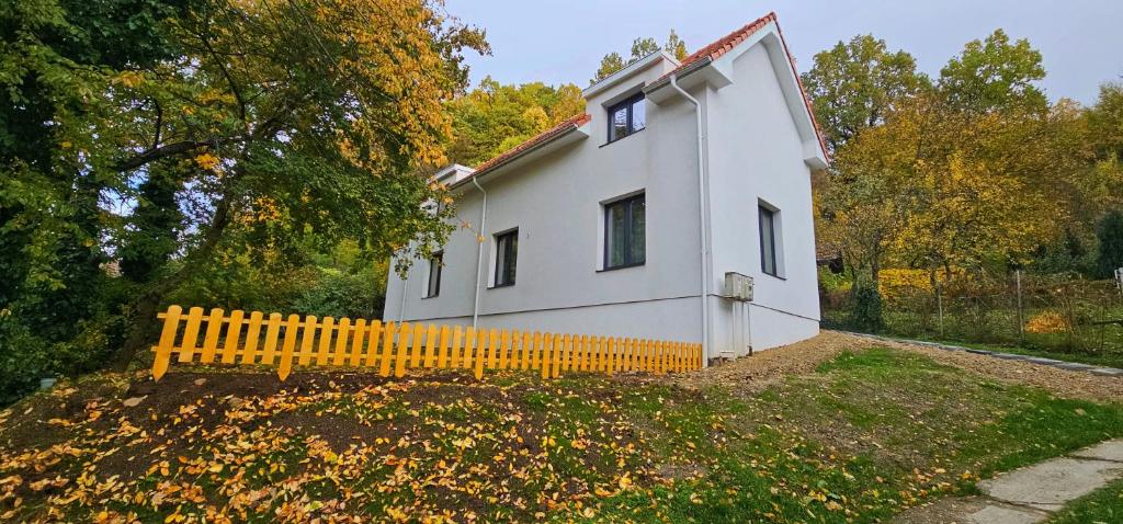 una pequeña casa blanca con una valla amarilla en Park home, en Baia Mare