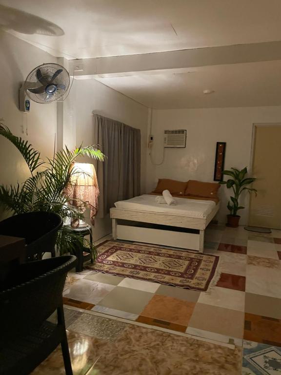 ein Wohnzimmer mit einem Bett und einigen Pflanzen in der Unterkunft Allegria Beachfront Resort in Alegria