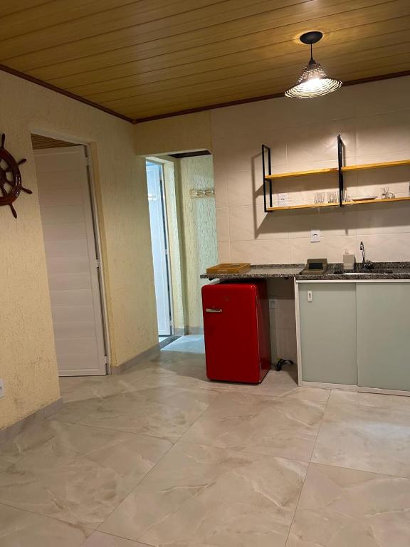 a kitchen with a red refrigerator in a room at Suite Tarituba 2 in Angra dos Reis
